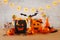 Holidays image of Halloween. Pumpkins, bats, treats, paper gift bag over wooden table