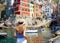 Holidays in Italy. Pretty young woman looking at the village of Riomaggiore from the harbor, Cinque Terre, Italy