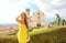 Holidays in Italy. Smiling beautiful tourist girl in Assisi, Italy. Attractive fashion woman with the Basilica of Saint Francis