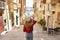 Holidays in Malta. Back view of traveler woman descends stairs in the historic city of Valletta, UNESCO World Heritage, Malta