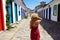 Holidays in Paraty, Brazil. Back view of beautiful fashion girl enjoying visiting historic town of Paraty, Rio de janeiro. Summer