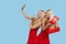 Holidays sales. Happy Women with gift boxes in red dresses on blue background,