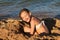 Holidays, summer day on the beach by the sea, the girl happily plays with sand