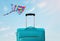 Holidays. travel concept. blue suitcase infront of blue sky with kite background