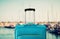 Holidays. travel concept. blue suitcase infront of marina background