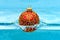 Holidays and vacation concept. Festive decoration for Christmas tree, red ball with glitter decor dropped into water