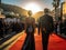 The Hollywood sign glows in the background as a dapper stylish couple walks down the red carpet at created with Generative AI