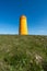 Holmsberg Lighthouse, an orange light house on the Reykjanes Peninsula in Iceland