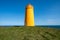 Holmsberg Lighthouse, an orange light house on the Reykjanes Peninsula in Iceland