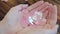 Holographic decor in the form of pink hearts for Valentine's Day in women's hands. Close-up view.