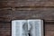 Holy Bible Book and magnifying glass on wooden background with copy space, top table view