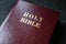 Holy Bible gold text on a leather cover book brown red color, close up view