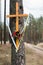 Holy cross at a dirt road in the forest. A forested sandy path l