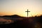 The holy cross of Jesus Christ on the grass with a strong light in the sunset sky