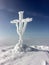 The holy cross on the top of the mount covered of frozen snow