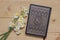 Holy Quran book and daffodils on the wooden background. Ramadan