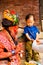 Holy Sadhu man with traditional painted face and colouful clothes is blessing a child at Pashupatinath Hindu Temple complex near K