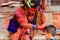 Holy Sadhu man with traditional painted face and colouful clothes is blessing a child at Pashupatinath Hindu Temple complex near K