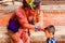 Holy Sadhu man with traditional painted face and colouful clothes is blessing a child at Pashupatinath Hindu Temple complex near K