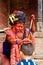 Holy Sadhu man with traditional painted face and colouful clothes is blessing a child at Pashupatinath Hindu Temple complex near K