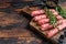 Homamade raw meat lula kebabs sausages on a cutting board. Dark wooden background. Top view. Copy space