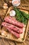 Homamade raw mince meat sausages on a cutting board. wooden background. Top view