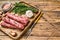 Homamade raw mince meat sausages on a cutting board. wooden background. Top view. Copy space