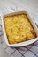 Home-baked Cheesy Amish Breakfast Casserole on a white wooden surface, low angle view. Closeup