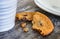 Home baked, choc chip cookies seen on a rustic table next to a coffee mug.