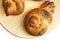 Home baked Easter brioche buns in birds shape with poppy seeds on wooden cutting board isolated on white