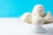 Home baked meringue cookies on white cake stand on blue wall background. French Italian Swiss desserts cuisine confection