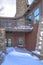 Home with balcony over snowy entrance built on Wasatch Mountain neighborhood