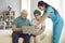 Home care nurse teaching her happy senior patients to use modern laptop computer