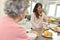 Home carer serving breakfast to a senior woman