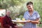 Home carer serving meal to elderly man