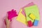 Home cleaning background. Woman hand hold rubber gloves, many sponges on pink background