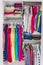 Home closet organized walk-in bedroom wardrobe of women fashion clothes hanging on racks. Summer style, dresses and t