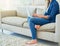 Home comforts. an unrecognizable young woman using her laptop while sitting on the sofa at home.