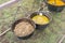 Home-cooked food in open air. Buckwheat porridge , chicken broth, sea buckthorn compote are in cast-iron pots fixed on chains.