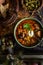 Home cooked solyanka meat soup served with bread, olives and capers, closeup view