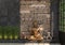 Home decor with a gold statue of Buddha against a black wall with an ethnic pattern of stones. The composition of a set of decorat