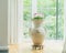 Home decoration with amphora or terracotta vase with flowers on window. Living room interior