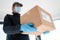 Home delivery shopping box man wearing gloves and protective mask delivering packages at door