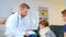 Home doctor came to sick boy and his mother. he examines a child and records readings in notebook