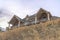 Home with dormer and two gable roofs over balcony with cloudy sky background