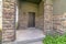 Home exterior with pillars and railing at the front porch and brown wooden door