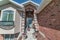 Home facade with brick wall and cozy portico with glass paned blue front door