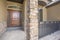 Home facade with brown wood door frosted sidelights and arched transom window