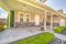 Home facade with concrete porch and white front door flanked by windows