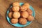 Home fried donuts on a blue plate on the wooden table.